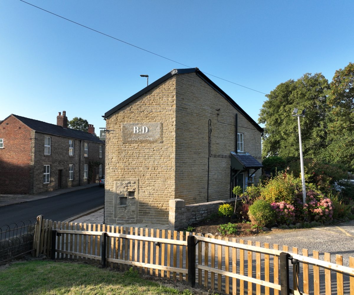 Bollington Dental Practice in evening light, seen from the recreation ground with the new gable sign